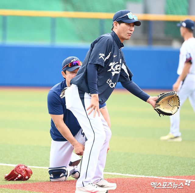 24일 일본 오키나와 카데나 구장에서 진행된 2026 월드베이스볼클래식(WBC) 대표팀의 2차 스프링캠프, 대표팀 강인권 코치가 글러브를 착용하고 포수 박동원을 보호하고 있다. 엑스포츠뉴스 DB