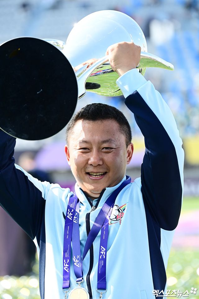 북한 내고향여자축구단 23일 오후 수원종합운동장에서 열린 2025-2026시즌 아시아축구연맹(AFC) 여자 챔피언스리그(AWCL) 결승전에서 일본 도쿄 베르디에 1-0으로 이긴 뒤 시상식에서 리유일 감독이 트로피를 높게 들어올리고 있다. 내고향은 전신인 AFC 여자 클럽 챔피언십을 포함해 이 대회에서 북한 팀으로는 처음으로 정상에 올랐다. 수원, 박지영 기자