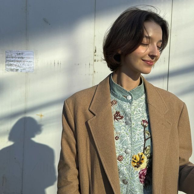 부드러운 카멜 코트와 플로럴 자수가 돋보이는 이너로 완성한 우아한 가을 룩/사진=안젤리나 다닐로바 인스타그램