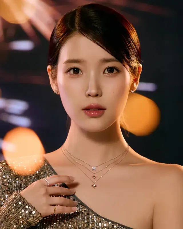 제이에스티나의 2025 홀리데이 캠페인에서 골드 오프숄더 드레스를 입고 고혹적인 매력을 발산하는 아이유의 모습. /사진=제이에스티나