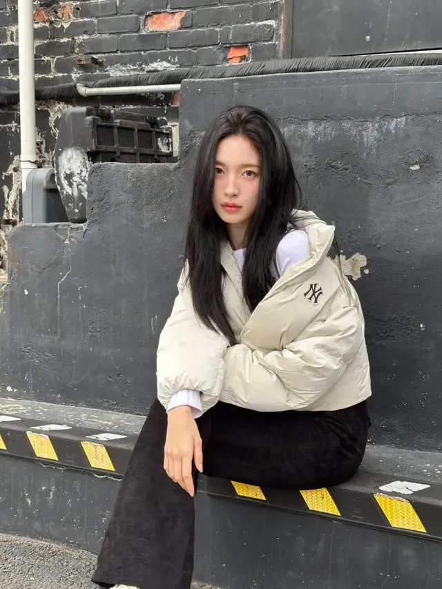 뉴욕 양키스 로고가 돋보이는 숏패딩과 벨벳 블랙 팬츠를 매치해 감각적인 데일리룩을 완성했다. /사진=아린 인스타그램