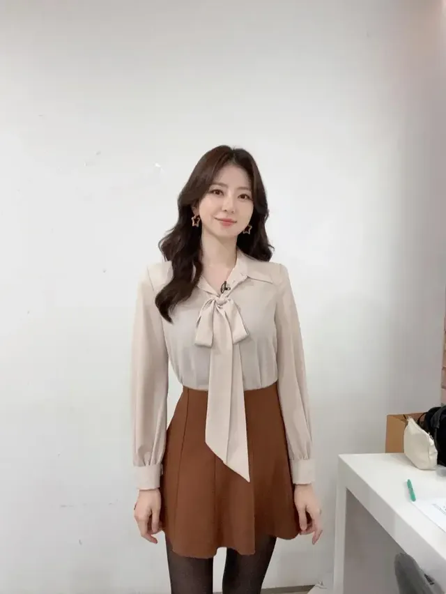 박지원이 실내에서 베이지 리본 블라우스와 브라운 스커트로 우아하면서도 단정한 오피스룩을 선보이며 시선을 사로잡는다. /사진=박지원 인스타그램