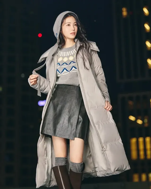 도시 야경을 배경으로 신예은이 그레이 롱 패딩과 노르딕 니트를 착용하고 따뜻한 윈터 감성을 연출한다. /사진=신예은 