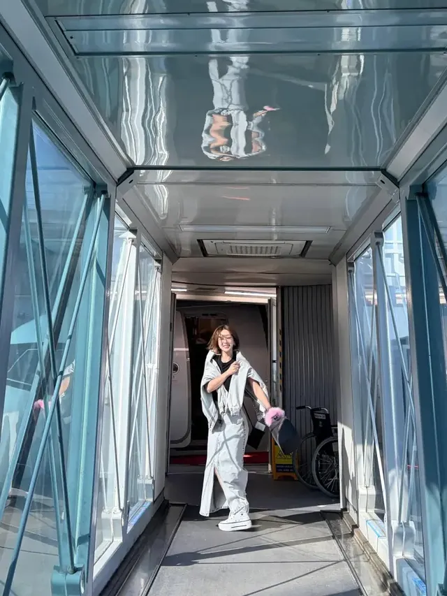 항공 탑승 브릿지에서 워싱 데님 재킷과 롱스커트로 자연스러운 여행룩을 선보이는 초아이다. /사진=초아 인스타그램