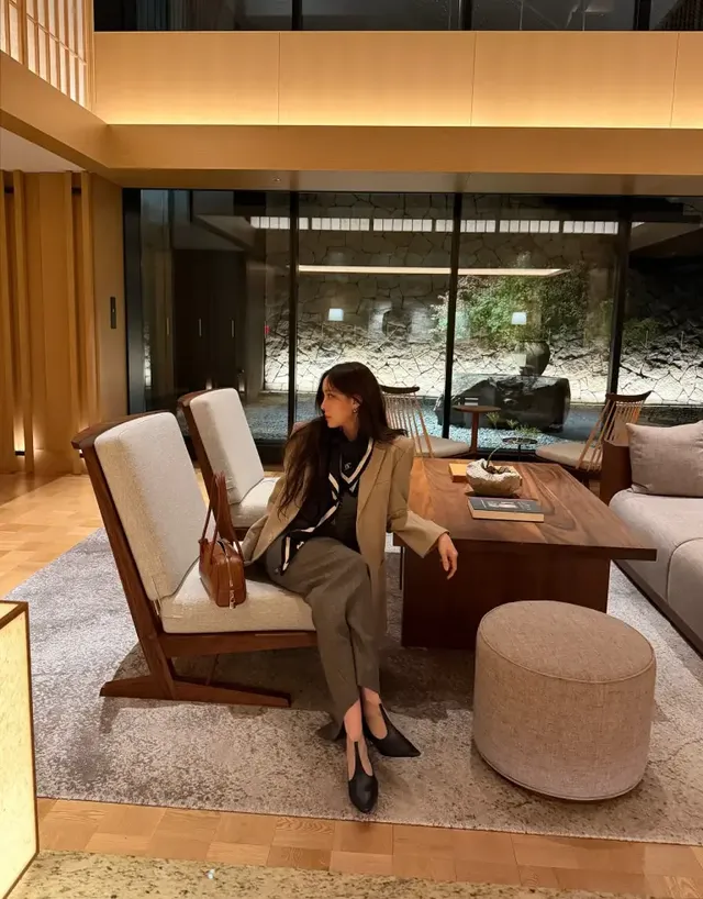  정갈한 레스토랑에서 효민이 민소매 다크 그레이 톱에 스카프를 더해 미니멀하면서도 도회적인 분위기를 연출하는 모습이다. /사진=효민 인스타그램