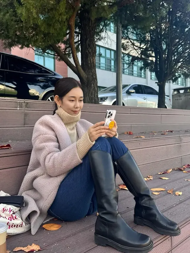 박탐희가 포근한 셰르파 코트 차림으로 가을 햇살 아래 데크 계단에 앉아 휴식을 취하는 모습. /사진=박탐희 인스타그램