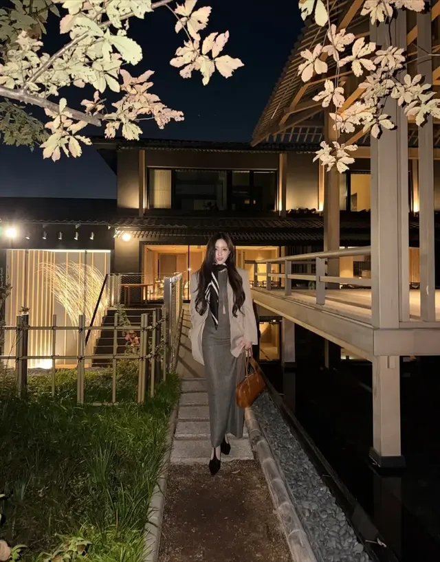 야외의 밤 풍경과 어우러진 효민이 롱 그레이 스커트와 브라운 토트백으로 우아한 가을밤 감성을 완성한다. /사진=효민 인스타그램