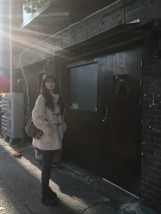 햇살 가득한 길가 벤치에 앉아 포근한 덤블 코트룩을 선보이는 추소정의 모습. /사진=추소정 인스타그램