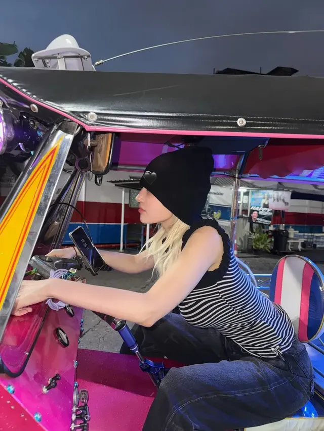 네온사인 빛이 감도는 밤거리에서 블랙 비니와 스트라이프 니트 슬리브리스로 힙한 스트리트 무드를 연출한 전소미. /사진=전소미 인스타그램