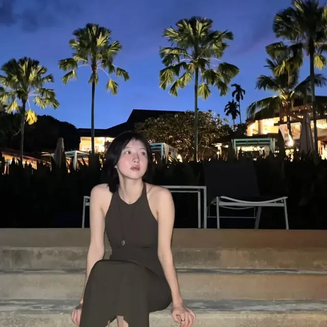 야외 조명 아래서 카메라를 응시하는 주현영의 모습. 미니멀한 카키빛 드레스와 자연스러운 포즈가 조화를 이룬다. /사진=주현영 인스타그램 