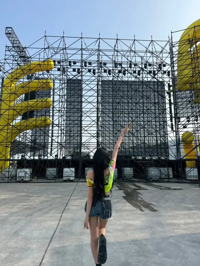 야외 무대 앞에서 경쾌한 포즈를 취하며 에너지를 발산하는 윤의 뒷모습이다. /사진=윤 인스타그램