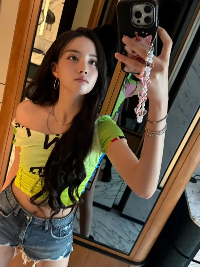 윤이 거울 셀카로 선보인 형광 라임 크롭티와 데님 쇼츠 페스티벌 룩이다. /사진=윤 인스타그램
