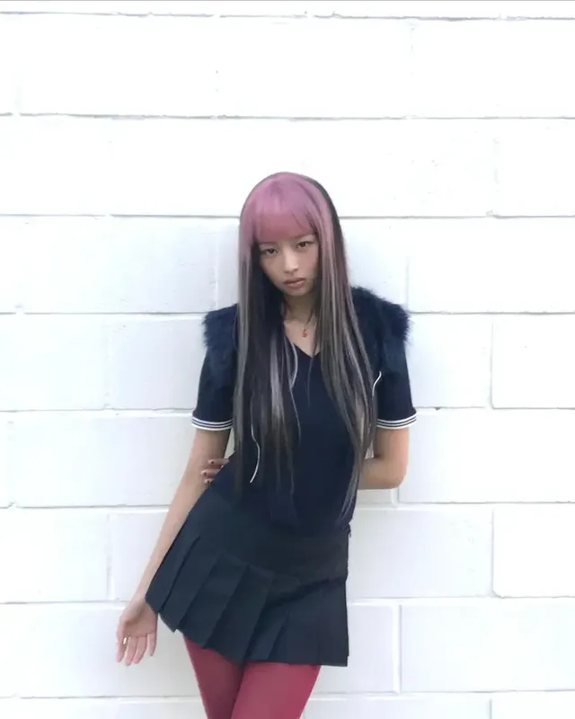  풍성한 퍼 디테일 상의와 레드빛 타이츠, 미니스커트, 그리고 핑크 헤어가 어우러져 레이의 강렬한 하이틴 감성을 표현한다. /사진=레이(REI) 인스타그램