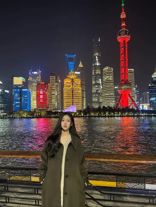 상하이 루저우의 화려한 스카이라인 아래, 올리브 롱코트로 도시의 밤을 물들인 송지우. /사진=송지우 인스타그램