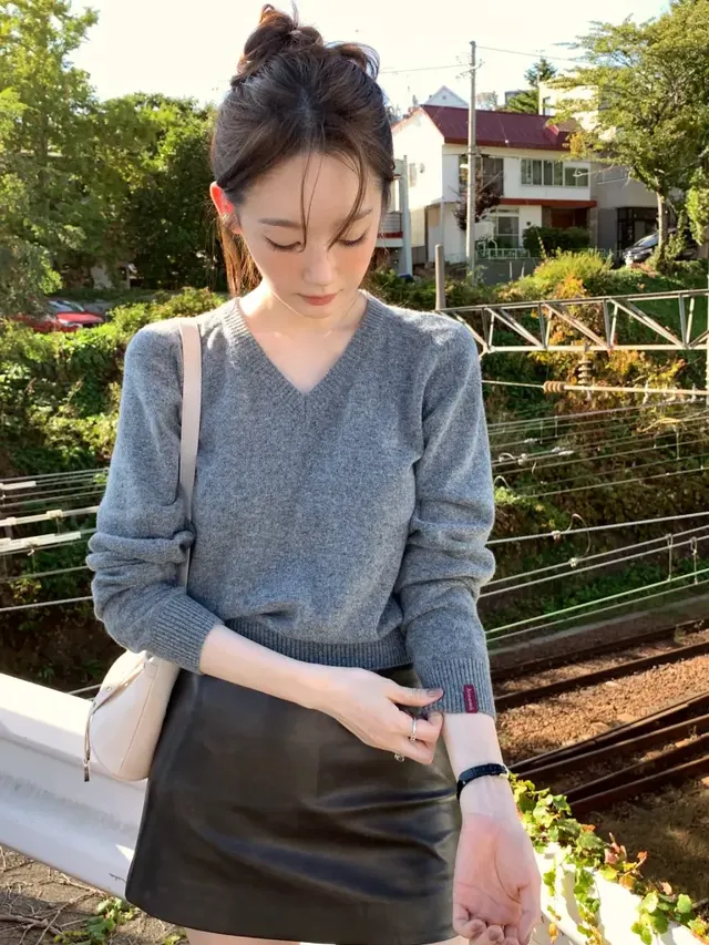 [캡션2] 햇살이 비추는 선로 위에서 브이넥 그레이 니트와 미니 레더 스커트를 매치한 강민경의 모습. /사진=강민경 인스타그램