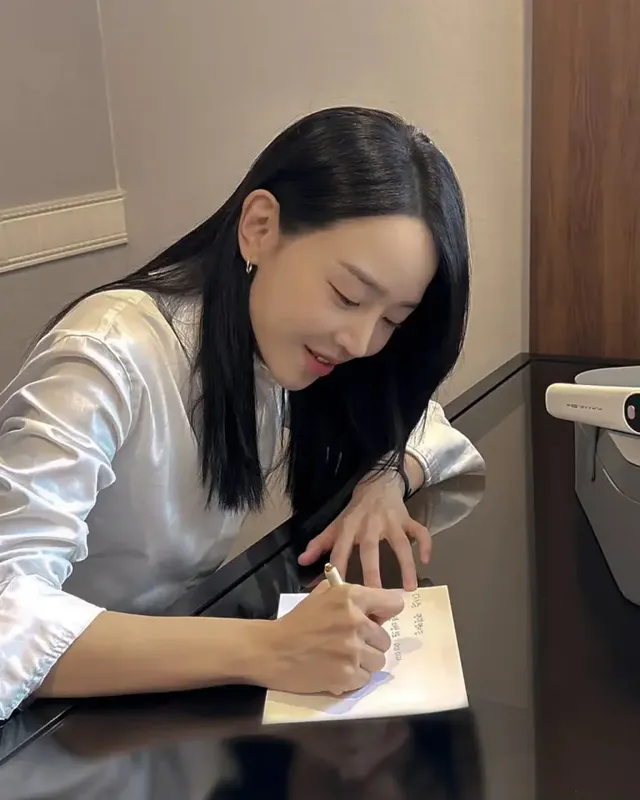 신혜선이 따뜻한 실내 조명 아래에서 실키 화이트 셔츠를 입고 고요하게 글을 쓰는 모습이다. /사진=신혜선 인스타그램