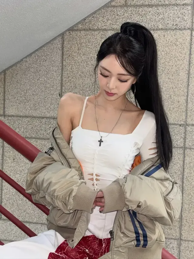 하이 포니테일로 연출된 브레이드 헤어스타일과 상체 라인을 강조하는 컷아웃 디테일 톱이 시선을 사로잡는다. /사진=유나 인스타그램