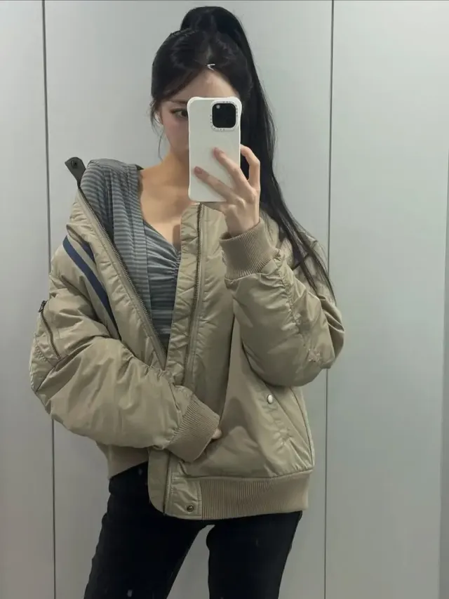 유나가 밝은 베이지 톤의 오버핏 항공점퍼와 슬림한 컷아웃 톱을 매치하여 독보적인 겨울 스트릿 룩을 선보이는 모습이다. /사진=유나 인스타그램