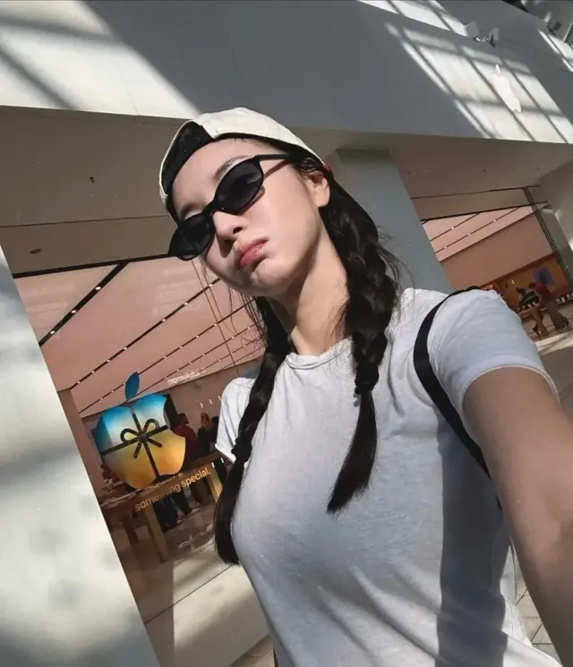 심플한 화이트 크루넥 티셔츠와 볼캡, 슬림한 선글라스로 도시적인 세련미를 더한 김윤지의 스타일링이다. /사진=김윤지 인스타그램