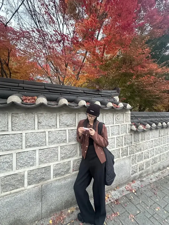  가을 단풍과 어우러진 브라운 스웨이드 재킷과 블랙 비니로 감각적인 무드를 연출한 김민주. /사진=김민주 인스타그램