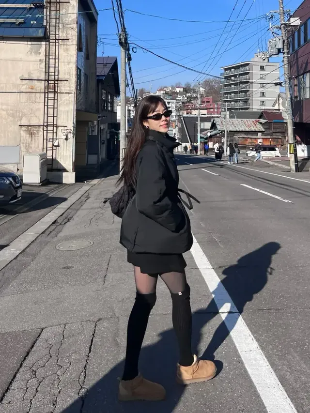 거리에서 노윤주가 올블랙 패딩과 니하이삭스, 어그 부츠로 보온성과 스타일을 모두 잡은 겨울 여행 패션을 연출하고 있다. /사진=노윤주 인스타그램 