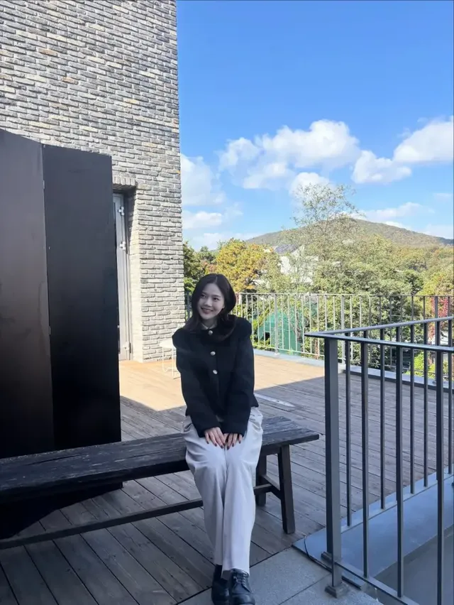 효정이 테라스에 앉아 화이트 셔츠를 이너로 매치한 단정한 블랙 재킷 스타일을 선보이며 여유로운 분위기를 자아낸다. /사진=효정 인스타그램