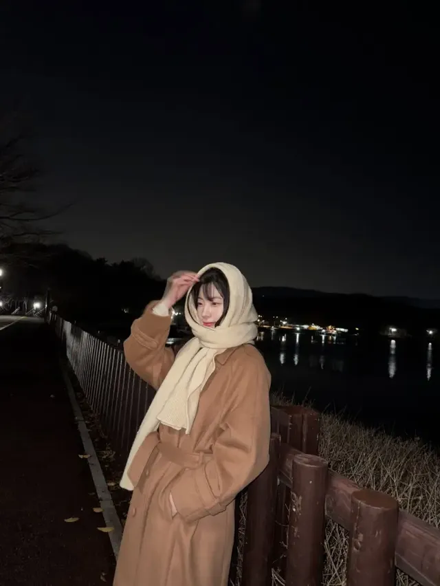 고요한 호숫가를 배경으로 브라운 롱 코트와 아이보리 스카프로 완성된 다현의 감성적인 겨울 스타일. /사진=다현 인스타그램