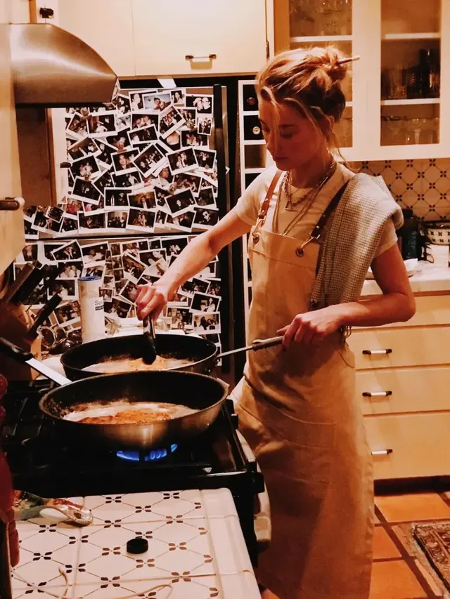 따뜻한 주방 조명 아래 베이지색 에이프런과 함께 요리하는 앰버 허드의 아늑한 모습. /사진=앰버 허드 인스타그램