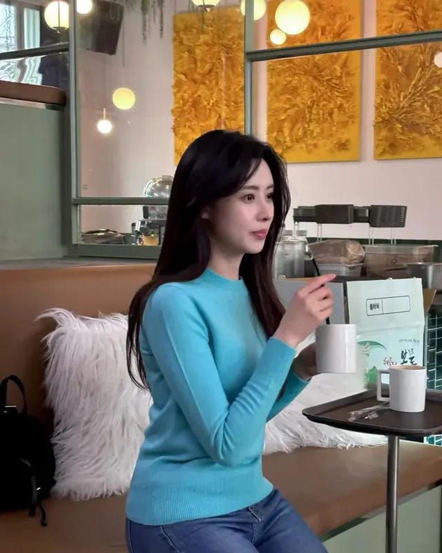 따뜻한 카페 공간에서 이유빈 아나운서가 하늘색 니트와 블랙 레깅스로 완성한 편안하면서도 세련된 데일리룩을 선보이고 있다. /사진=이유빈 인스타그램