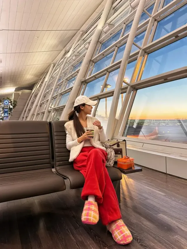 화이트 퍼 베스트와 레드 벨벳 팬츠, 체크 퍼 슬리퍼의 조화가 돋보이는 김희정의 공항 라운지룩 전신 모습. /사진=김희정 인스타그램