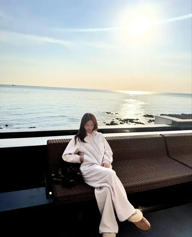 제주 바다와 붉은 석양을 배경으로 테라스에 앉아 미니멀 라운지웨어 룩을 선보인 이주빈. /사진=이주빈 인스타그램 