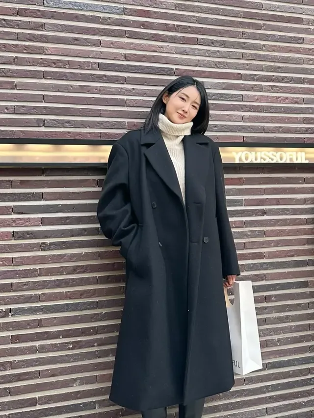 유다연이 크리스마스 트리를 배경으로 세련된 블랙 오버코트 룩을 선보인다. /사진=유다연 인스타그램