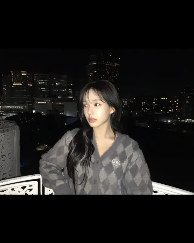 고층 빌딩의 야경을 배경으로 차분한 그레이 아가일 카디건을 착용한 이즈나 유사랑의 모습. /사진=이즈나 인스타그램