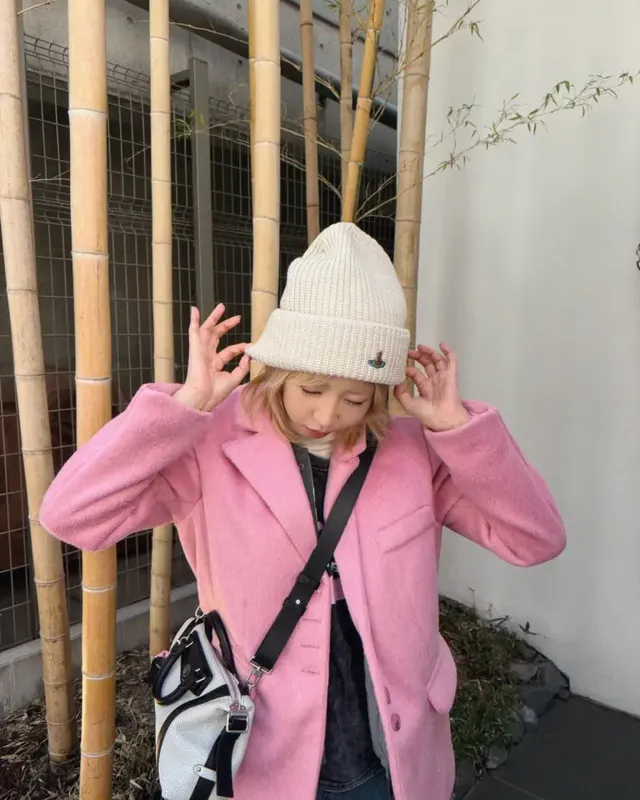 니트 비니를 고쳐 쓰며 자연스러운 포즈로 핑크 코트의 유려한 실루엣과 크로스백 스타일링을 강조한 장면이다. /사진=공민지 인스타그램
