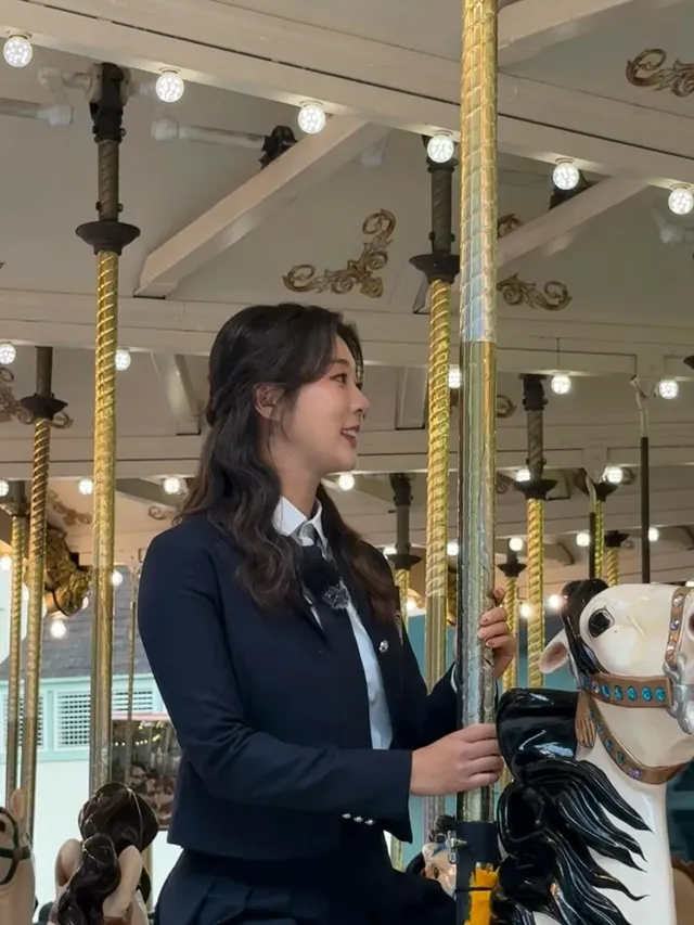 놀이공원의 회전목마 위에서 포즈를 취하며 세련된 네이비 셋업을 선보이는 김재희 프로골퍼의 모습. /사진=김재희 인스타그램
