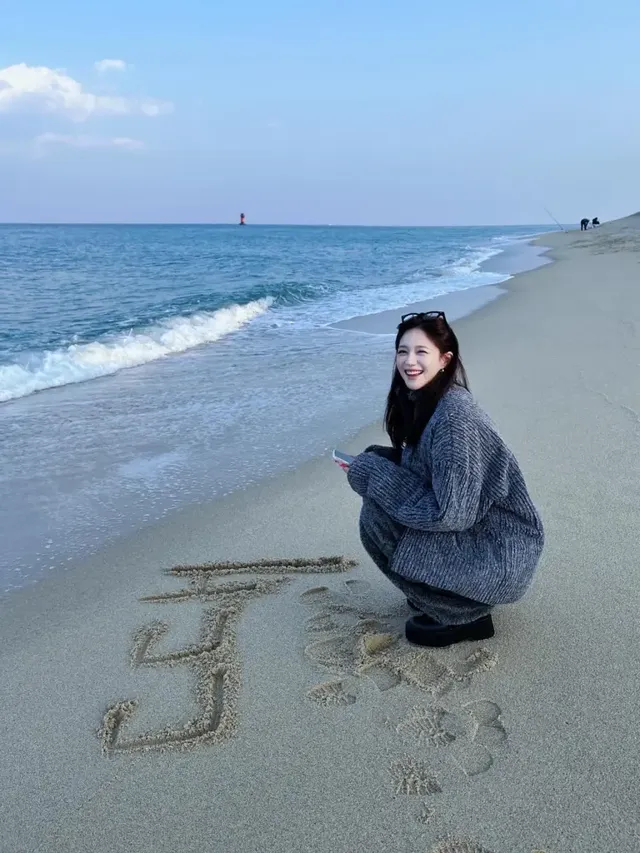 겨울 바다 모래사장 위에서 공연 제목을 적으며 환하게 웃고 있는 이엘리야의 청순한 모습. /사진=이엘리야 인스타그램