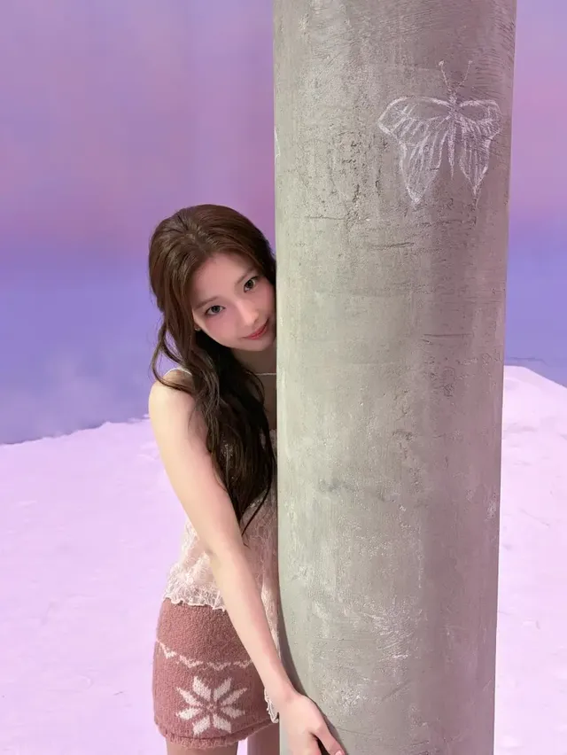 기둥 뒤에서 수줍게 미소 지으며 니트 스커트와 레이스 톱으로 사랑스러운 매력을 발산하는 루카. /사진=루카 인스타그램