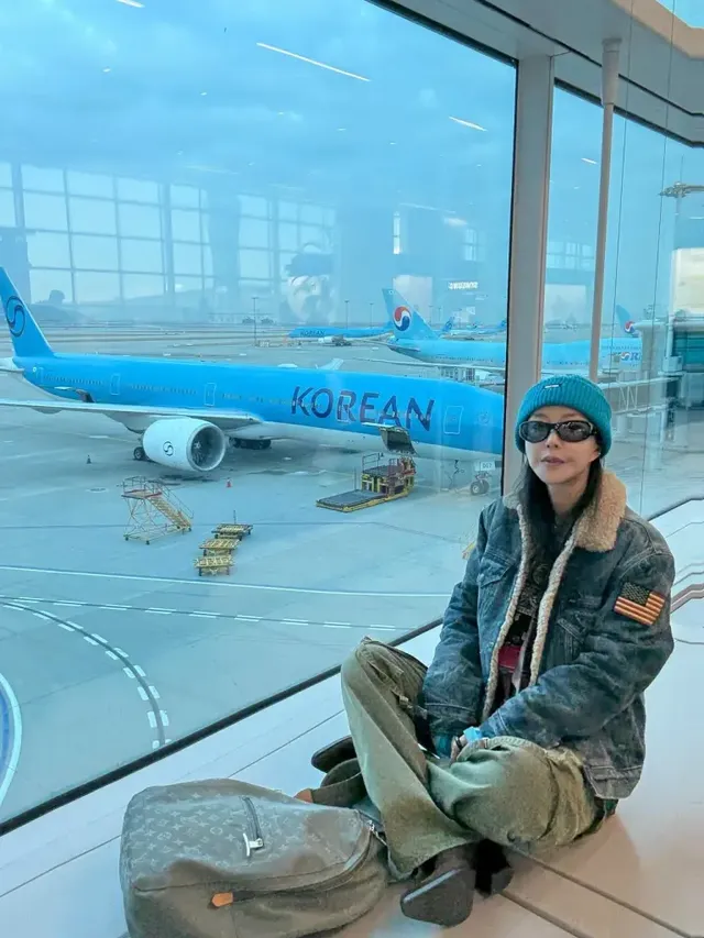 커다란 대한항공 항공기가 보이는 창가에서 여유로운 포즈로 새로운 시작에 대한 설렘을 드러내는 슈. /사진=슈 인스타그램