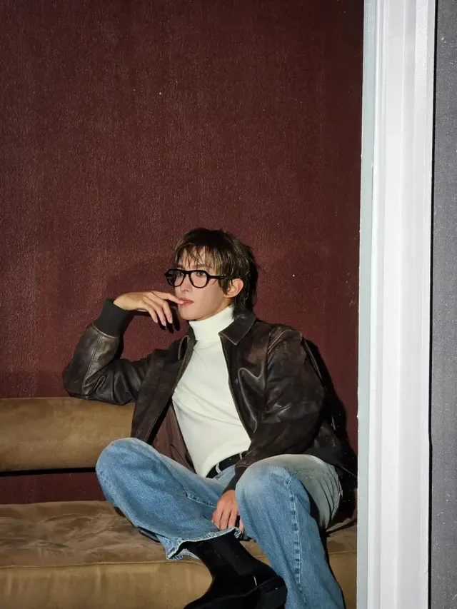 뿔테 안경과 레더 재킷으로 지적이면서도 시크한 분위기를 연출하며 소파에 앉아 있는 도겸. /사진=도겸 인스타그램