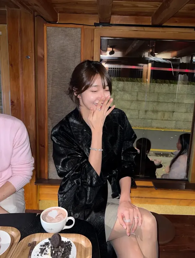 고요한 카페 공간에서 블랙 텍스처 코트가 연출하는 시크한 겨울 무드. /사진=오또맘 인스타그램