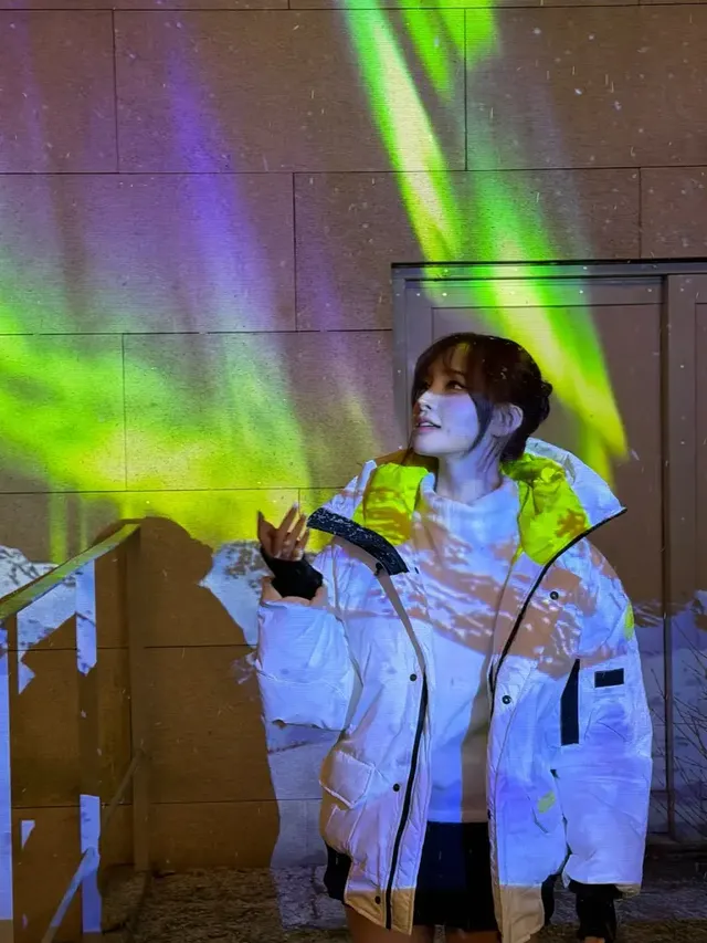  따뜻한 아이보리 터틀넥과 대조적인 형광 라임 디테일이 돋보이는 리즈의 패딩 룩. /사진=리즈 인스타그램