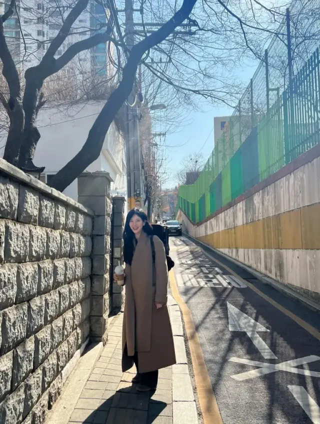 브라운 맥시 코트 | 햇살 가득한 돌담길을 런웨이로 바꾼 내추럴한 데일리 스타일링 /사진=서현 인스타그램