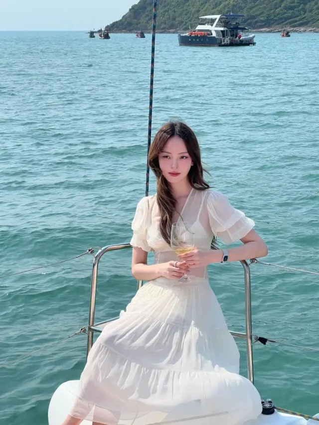 에메랄드빛 바다를 배경으로 난간에 기댄 요트룩