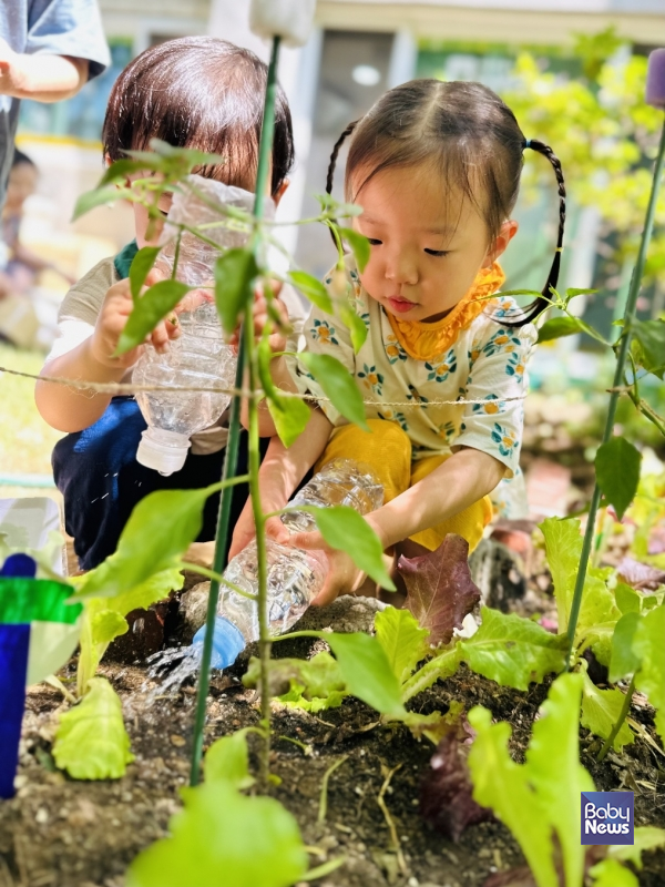 꿈동산 텃밭 정원에서 농작물에 물을 주고 있는 아이들. ⓒ김옥심