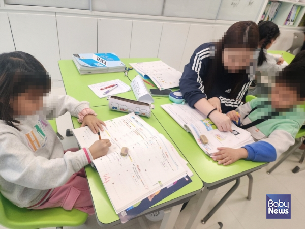 이주배경아동이 LH행복꿈터 우리마을 지역아동센터에서 봉사자와 함께 학습하고 있다. ⓒ초록우산