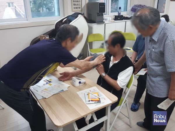 건강경로당에서 어르신이 올바른 혈압 측정법을 실습하고 있다.