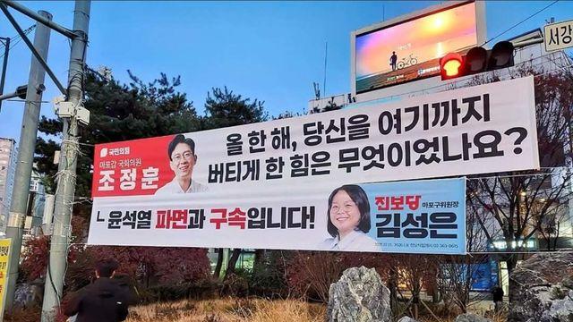 국민의힘 의원 플래카드 바로 밑에 대답하듯 걸린 플래카드의 정체